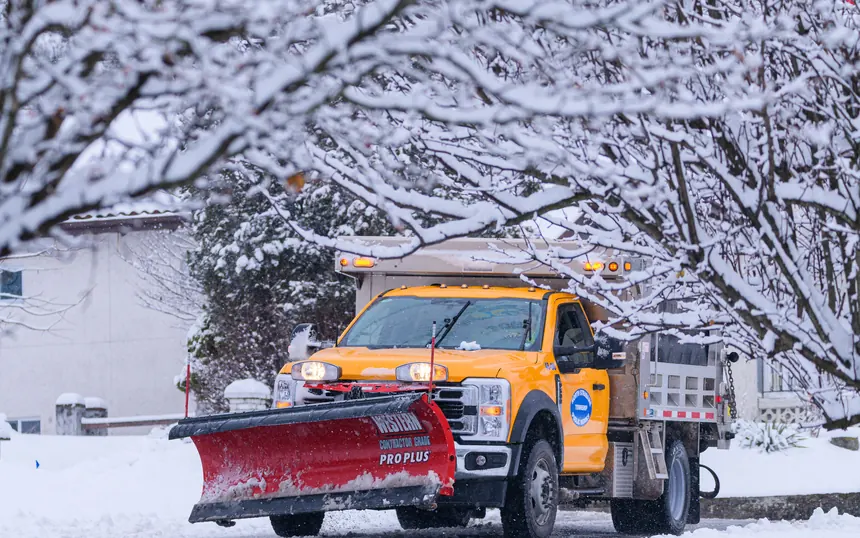 A plow truck on a snow covered road after a storm