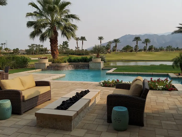 A pool deck in wide format pavers with planted screening