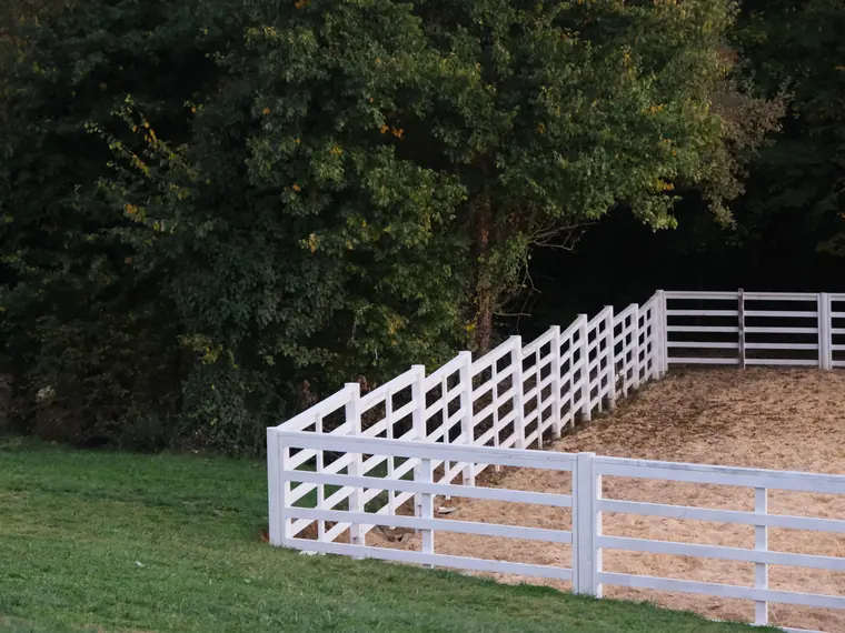 A white picket fence running along a front garden of a shingled house